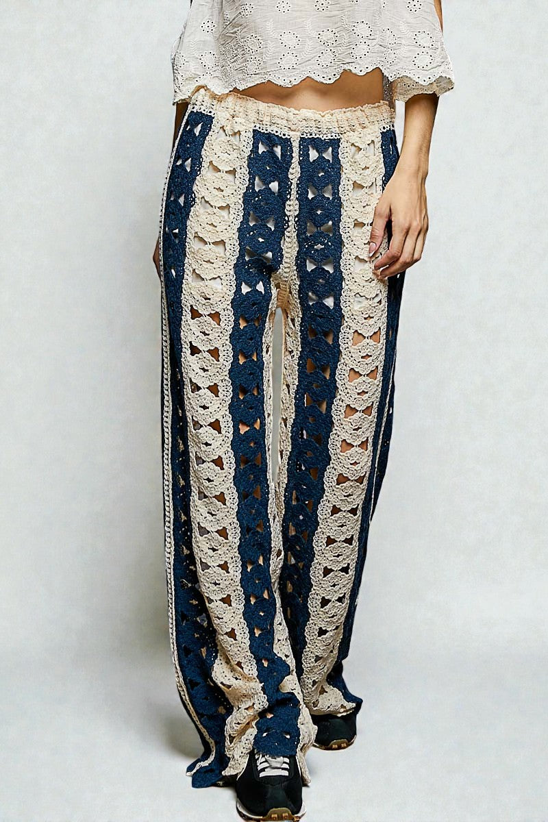 Person wearing blue and beige lace pants on a white background