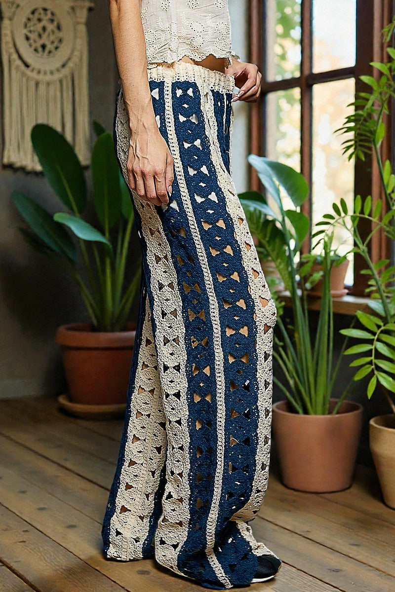 Person wearing a patterned blue and white outfit with plants in the background