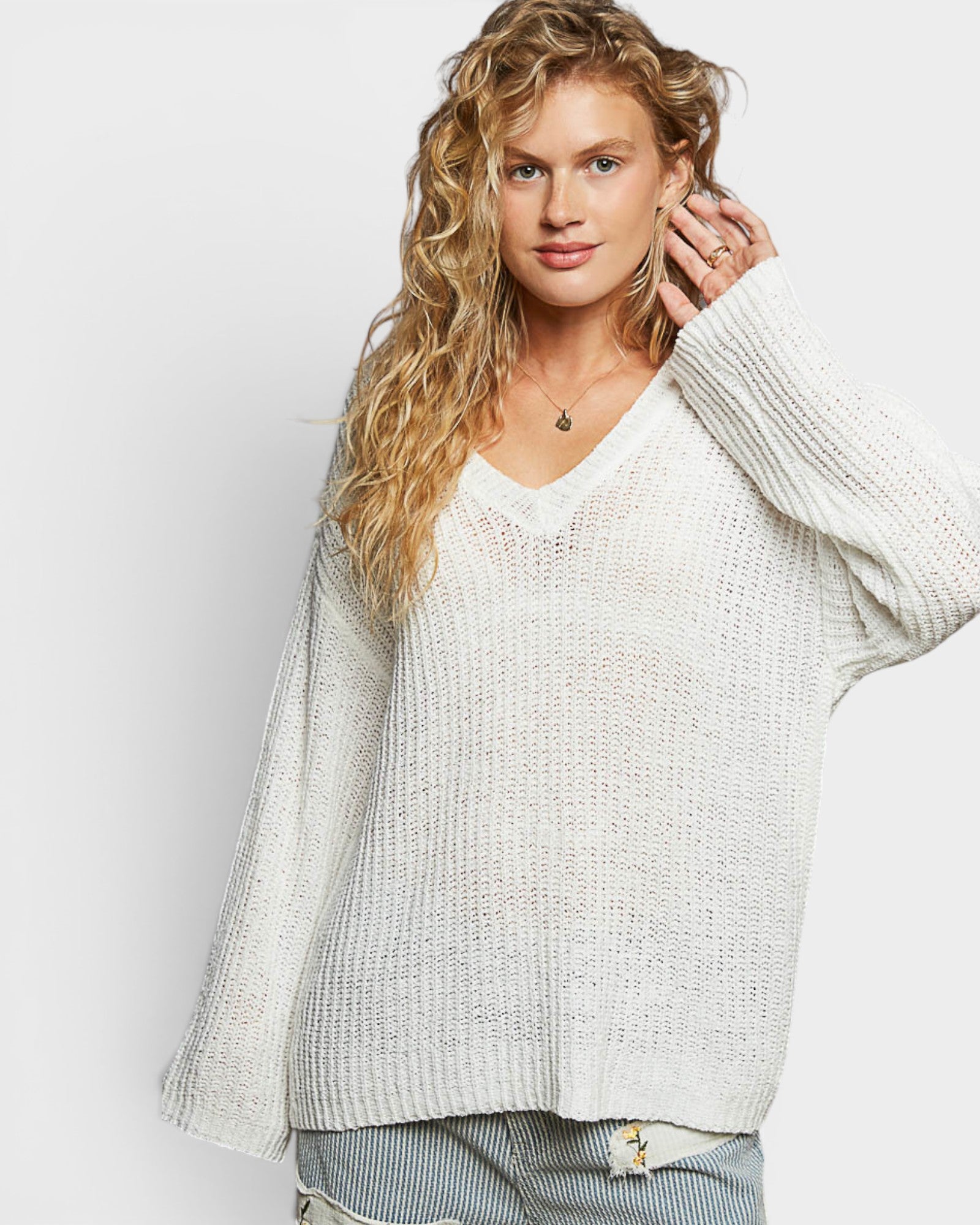 Woman wearing a light gray sweater against a white background