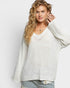 Woman wearing a light gray sweater against a white background