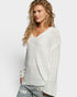 Woman wearing a light gray sweater on a white background