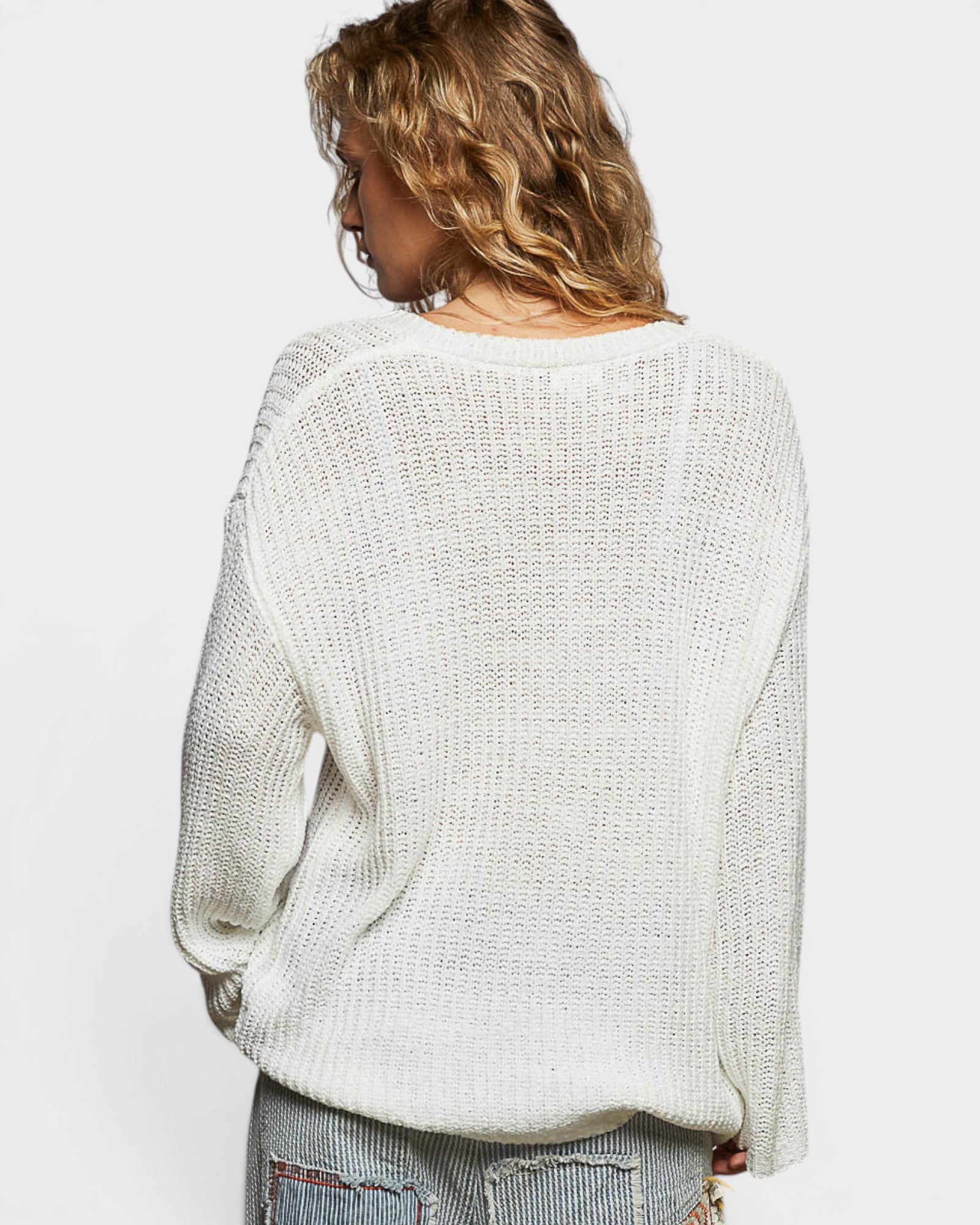 Person wearing a light gray sweater on a white background