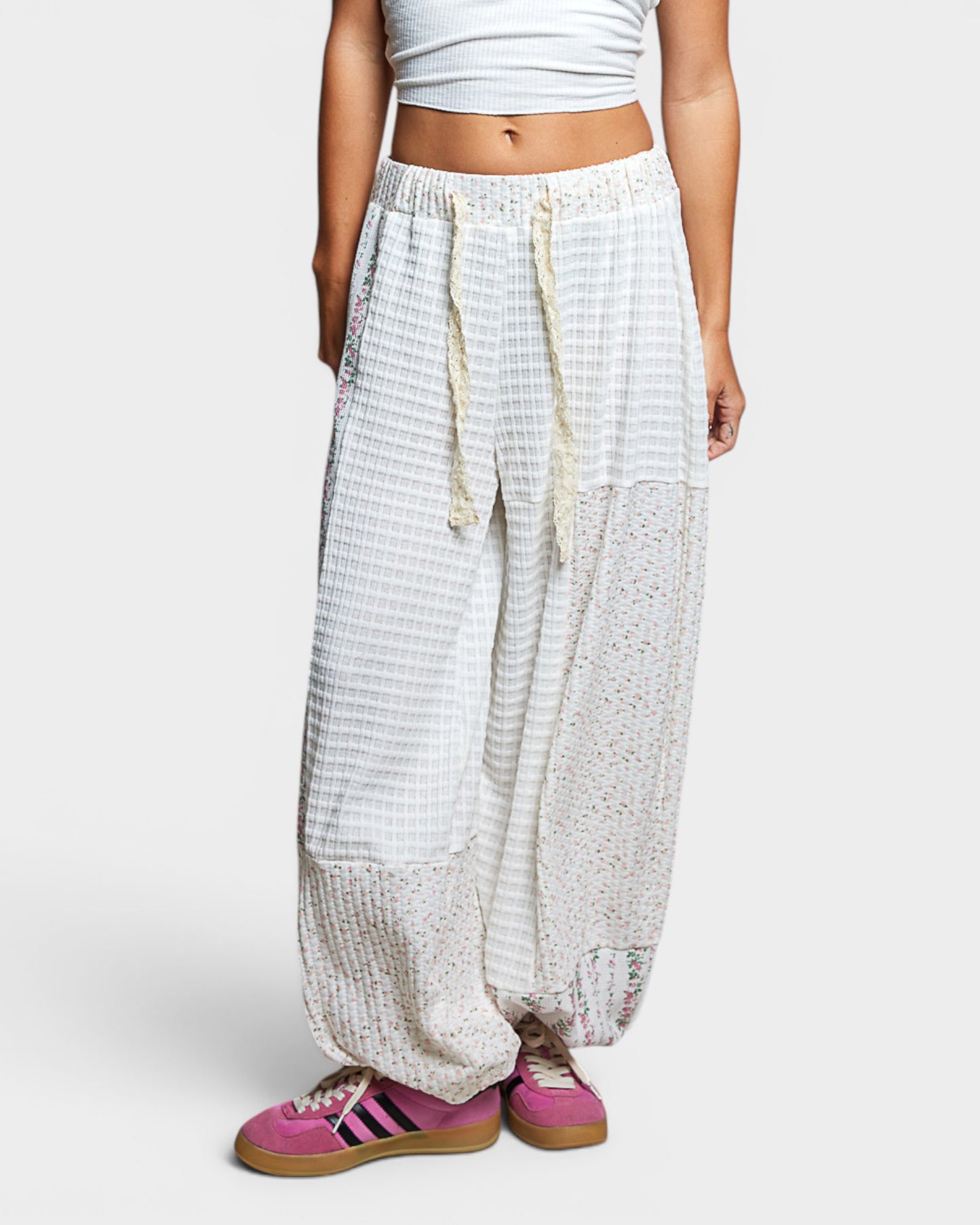 Person wearing white checkered pants with a plain background