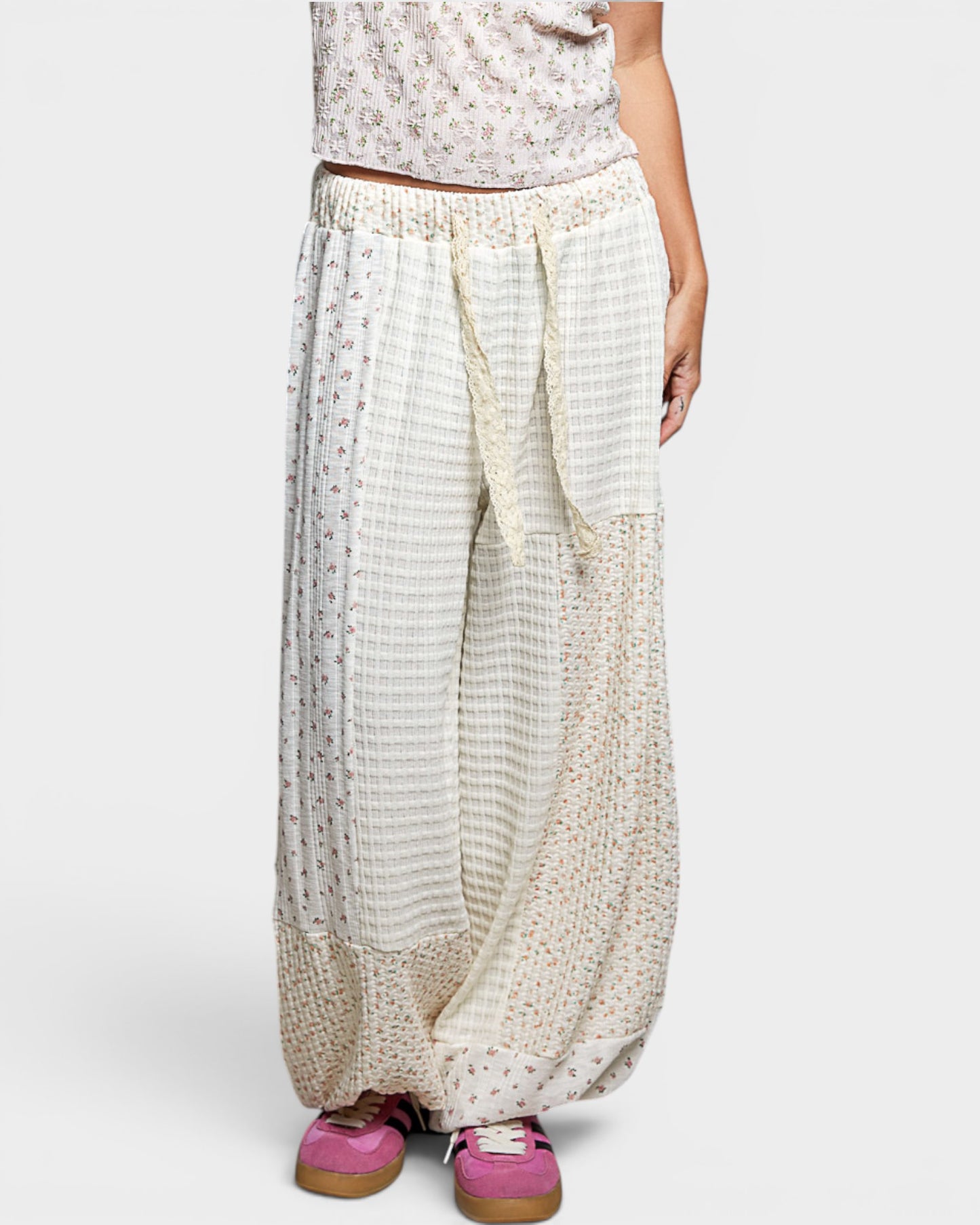 Person wearing a pair of wide-leg pants with a white background