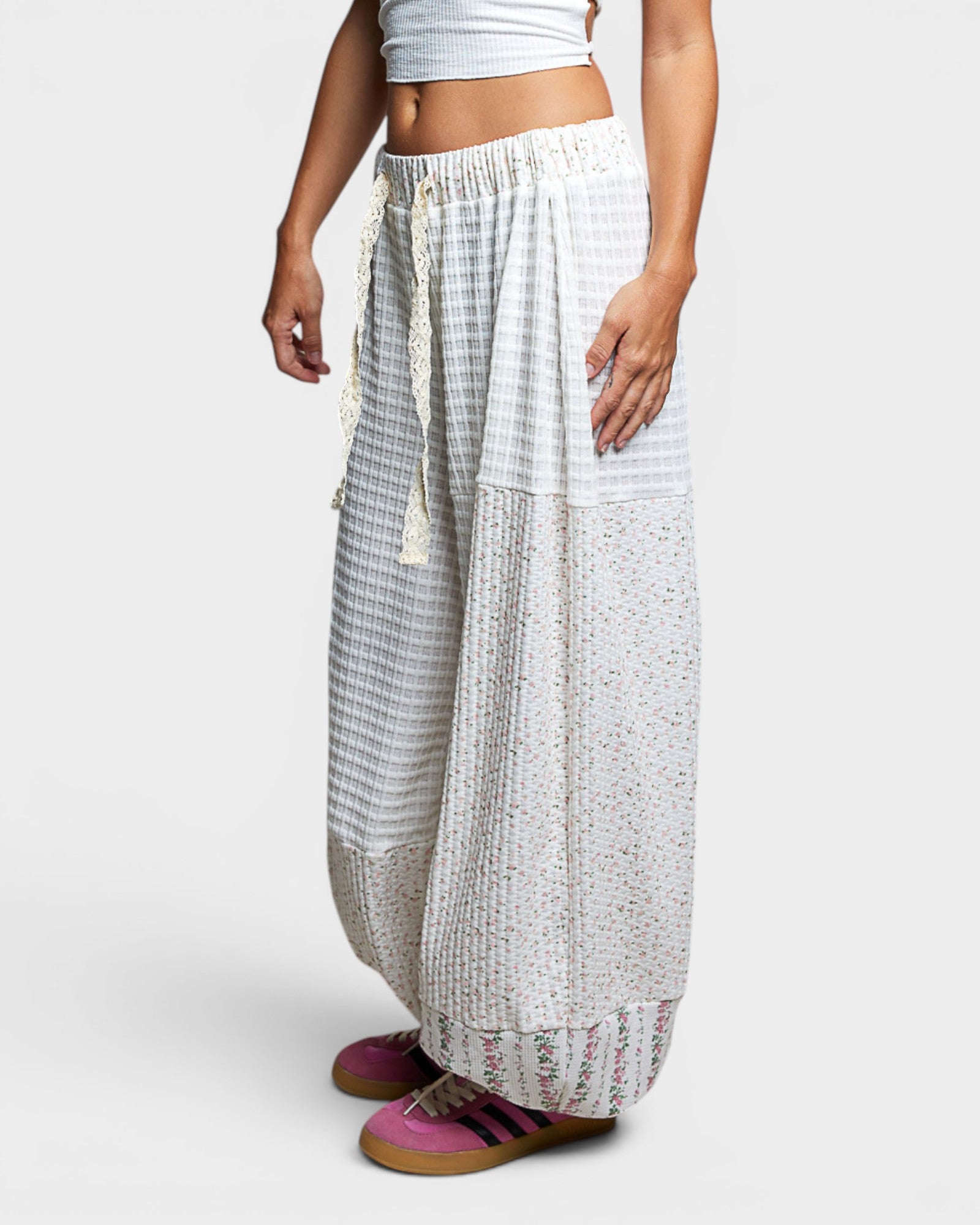 Person wearing a white and gray patterned wide-leg pants on a white background