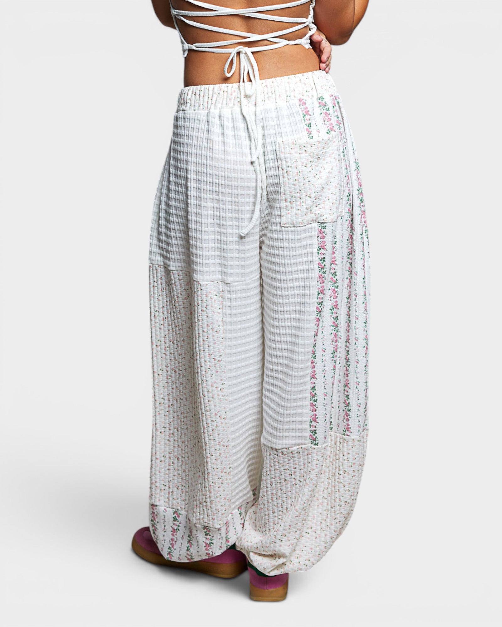 White patterned pants worn by a person on a white background