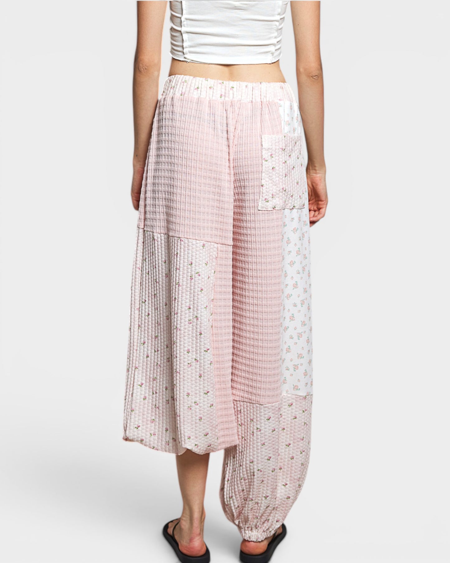 Person wearing patterned pants on a white background