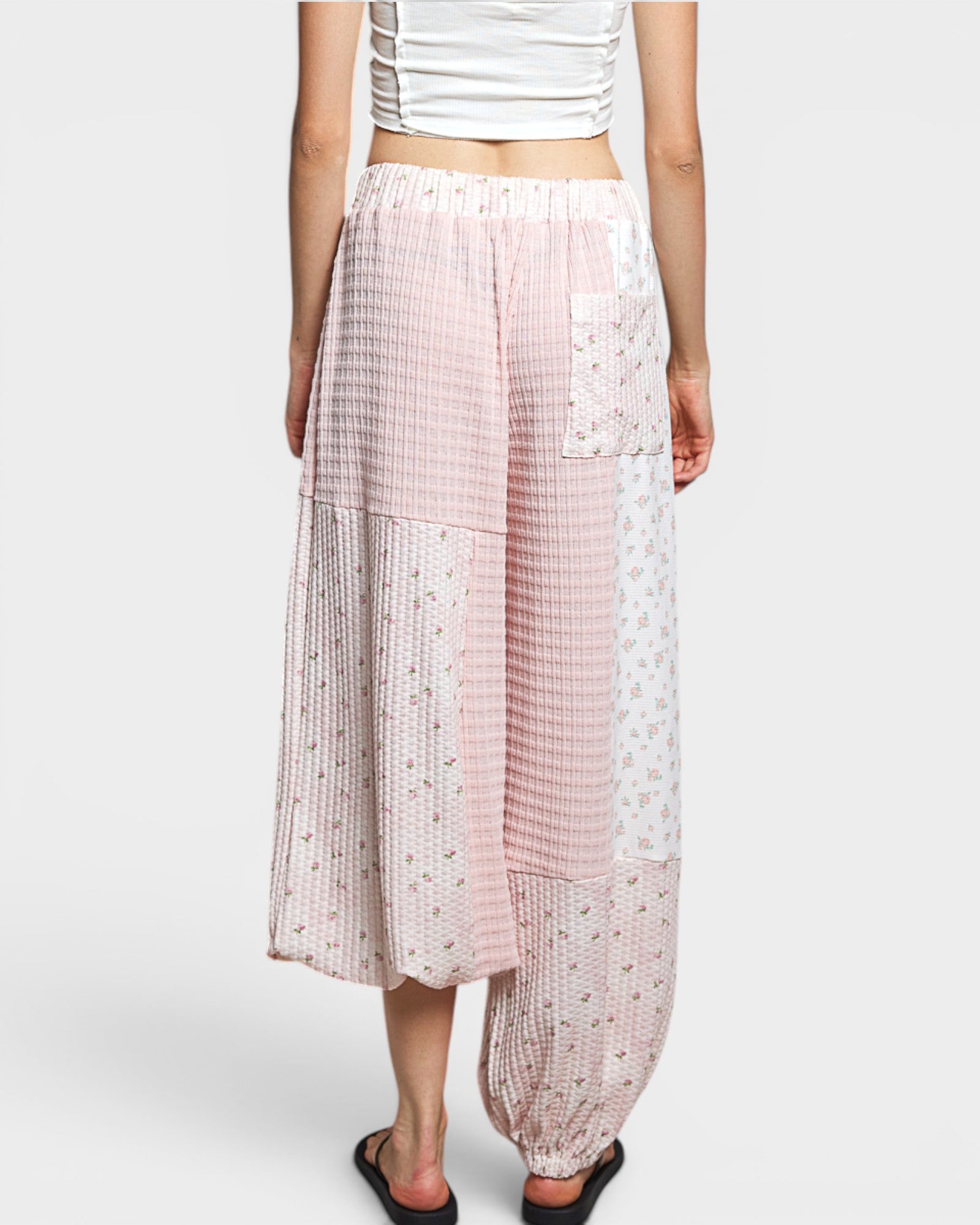 Person wearing patterned pants on a white background