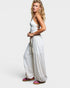 Woman wearing a white top and patterned pants on a plain background