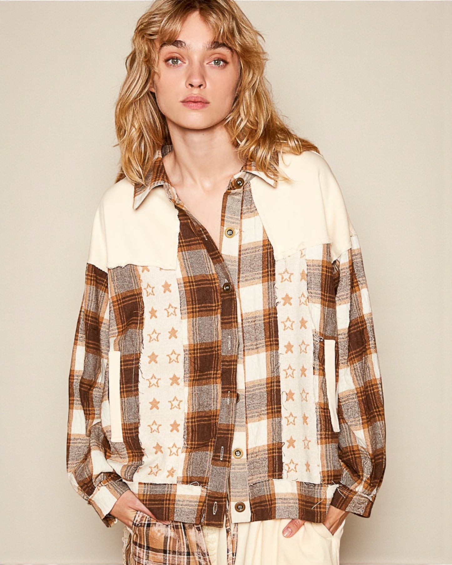 Woman wearing a plaid shirt with star patterns against a plain background