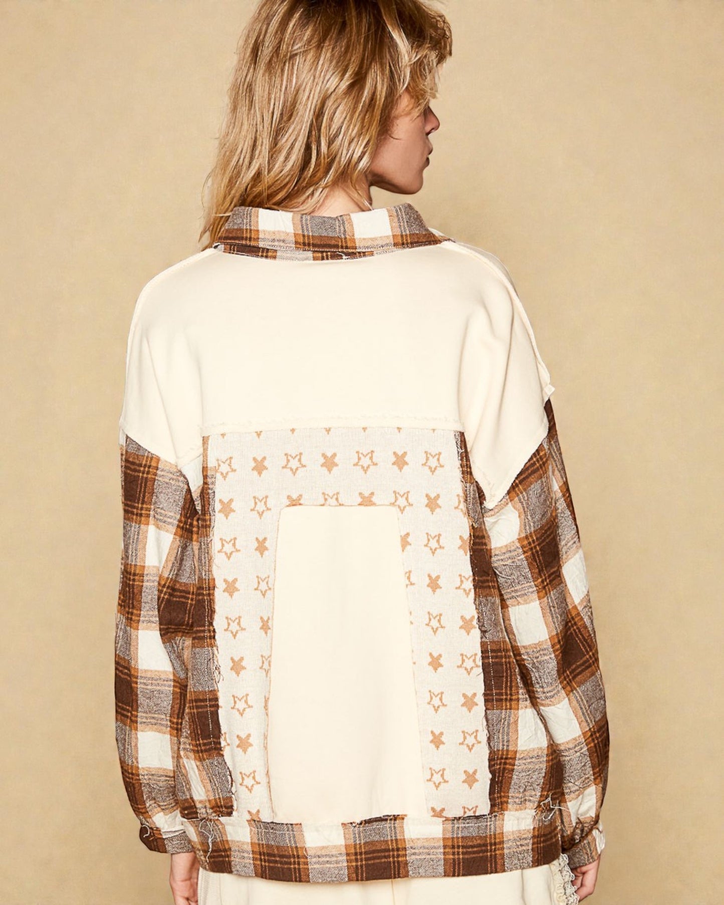 Person wearing a plaid shirt with star pattern on a beige background
