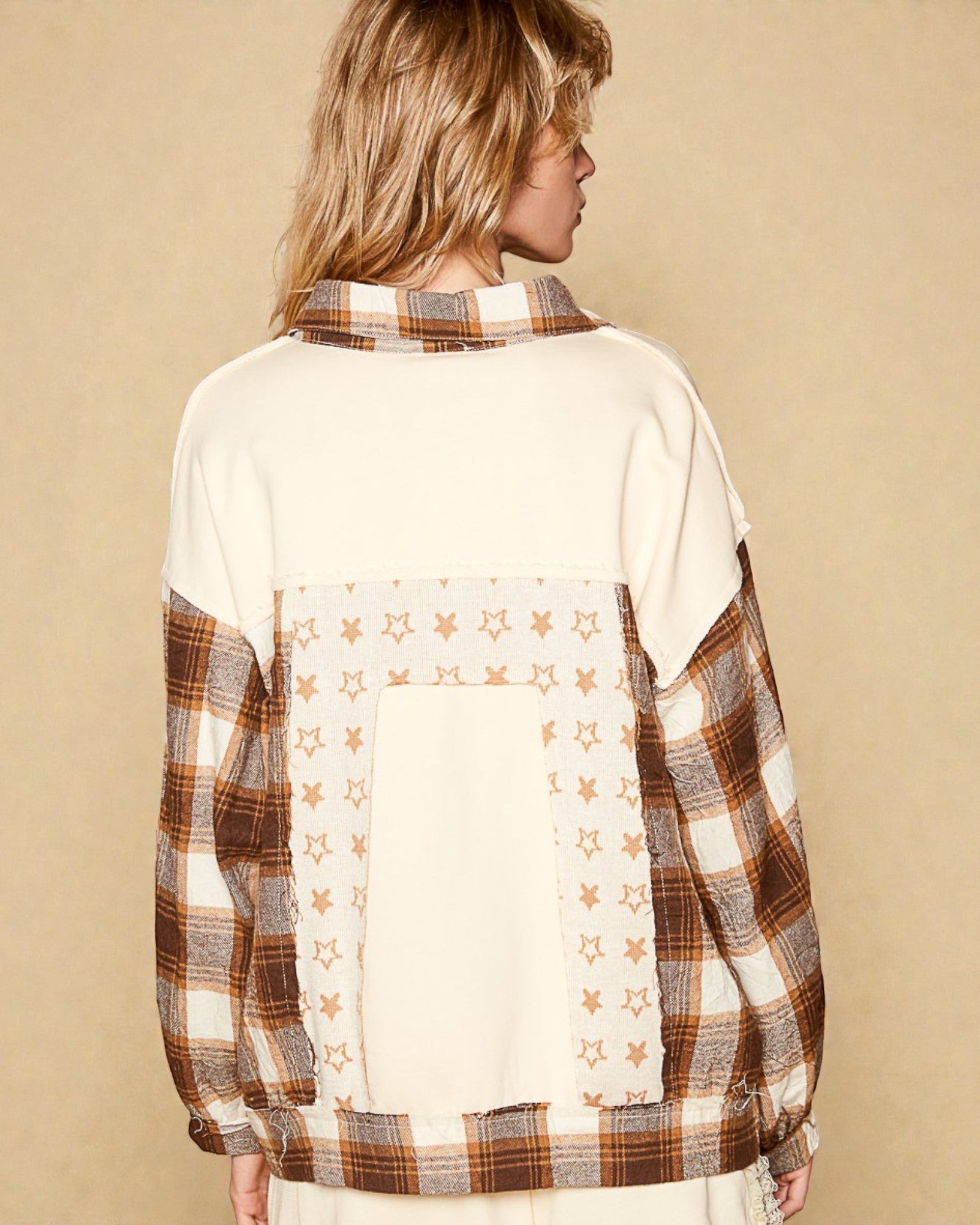 Person wearing a plaid shirt with star pattern on a beige background