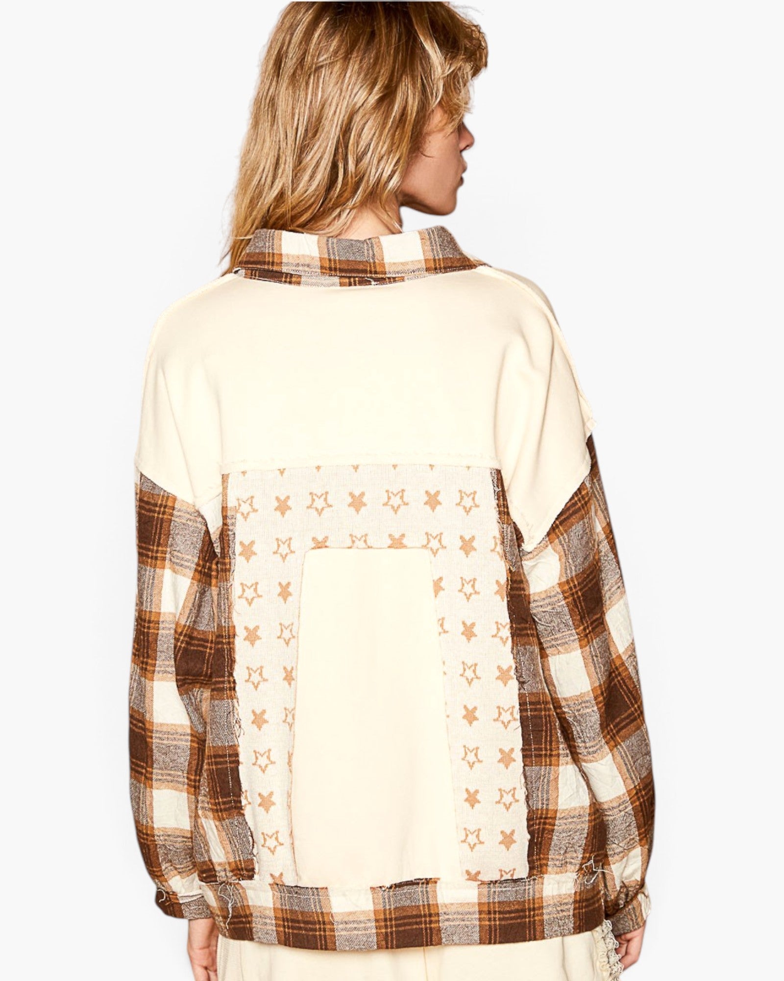 A woman shown from the back wearing a patchwork sweatshirt with cream panels, brown and beige plaid sleeves, and star-patterned applique details.