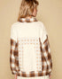 Person wearing a plaid shirt with star pattern on a beige background