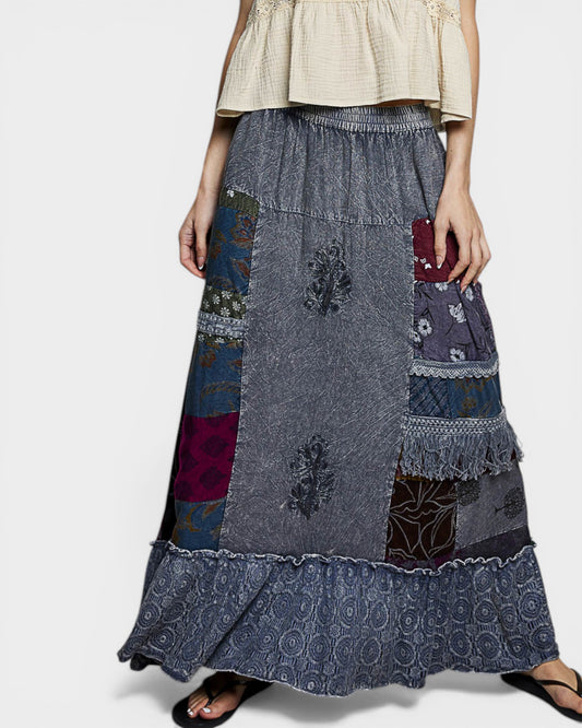 Woman wearing a patchwork skirt with a plain background