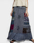 Woman wearing a patchwork skirt with a plain background