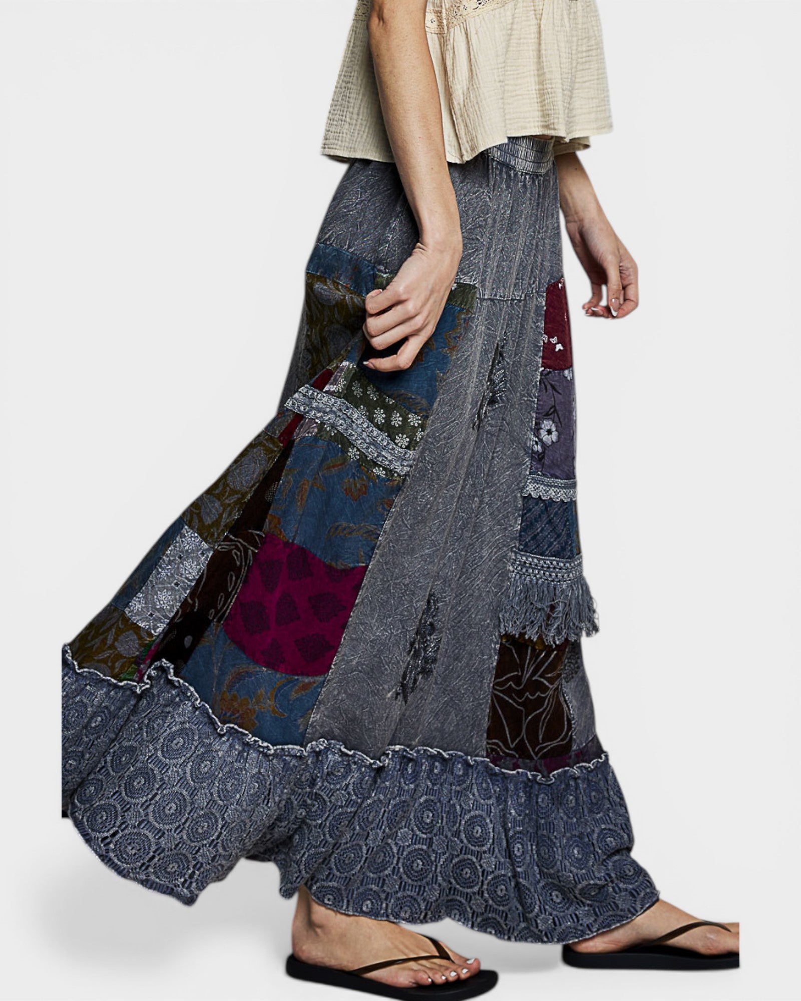Person wearing a patchwork denim skirt on a white background