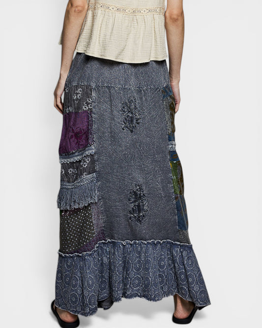 Long patchwork skirt with a white top on a plain background