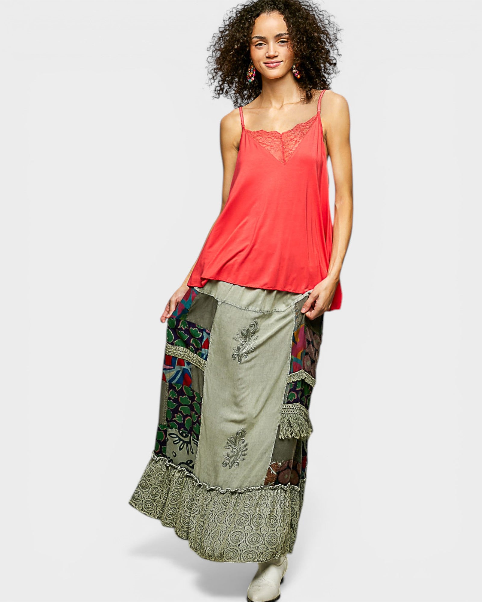 Woman wearing a red top and a long, patterned skirt on a white background