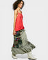 Woman wearing a colorful, layered skirt with a plain background