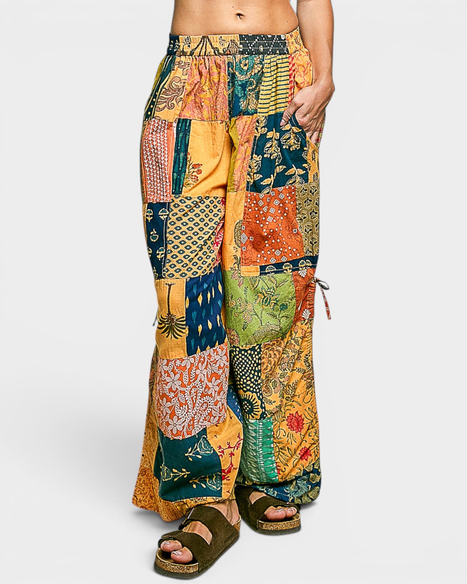 Colorful patchwork pants worn by a person on a white background
