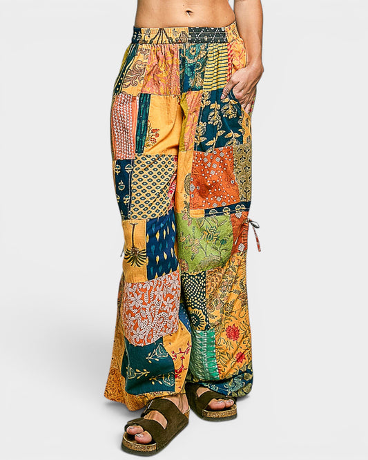 Colorful patchwork pants worn by a person on a white background