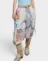 Person wearing colorful patchwork pants with a plain background
