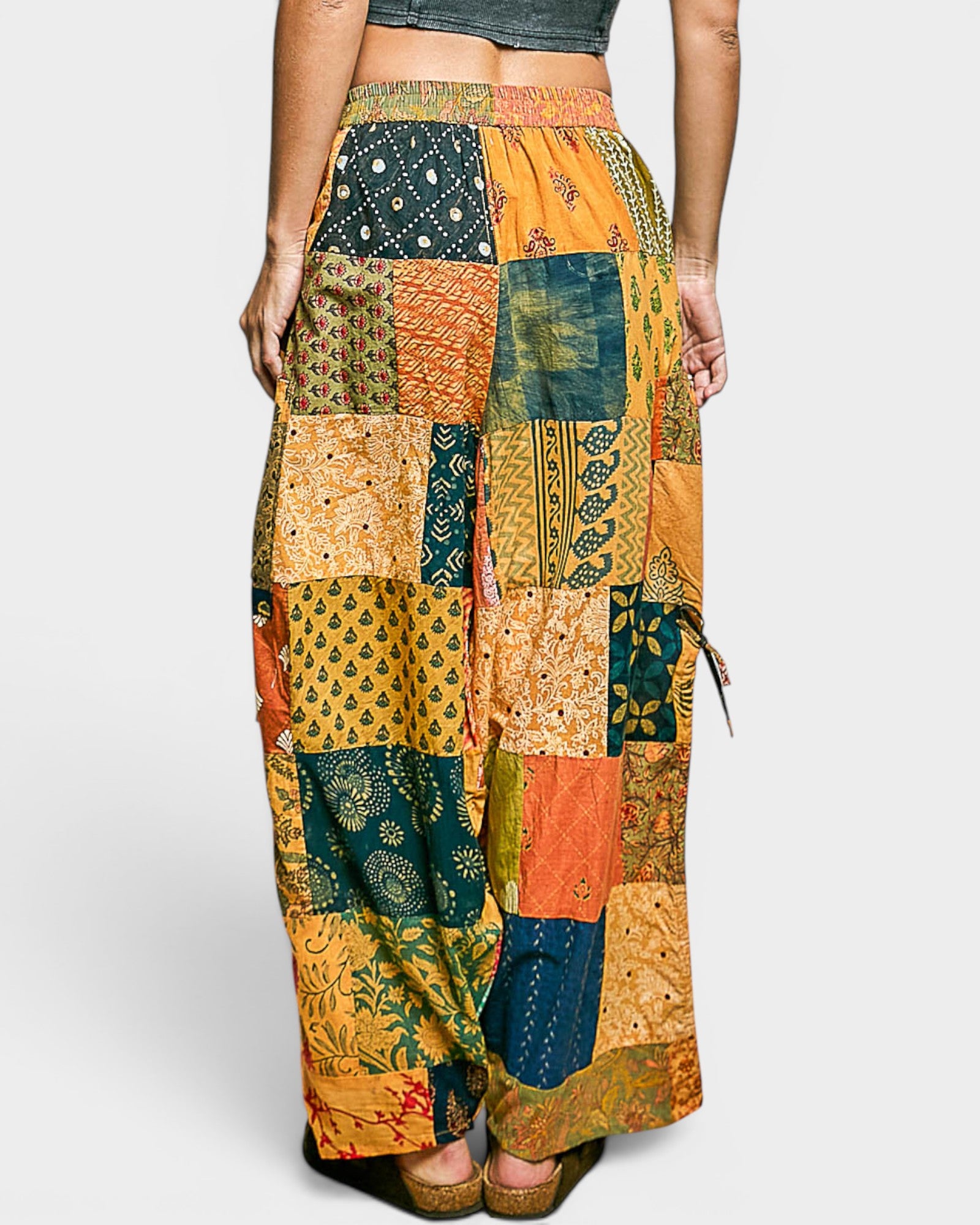 Multicolored patchwork pants worn by a person on a white background