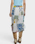 Person wearing a colorful patchwork skirt on a white background