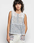 Woman wearing a sleeveless floral top against a plain background