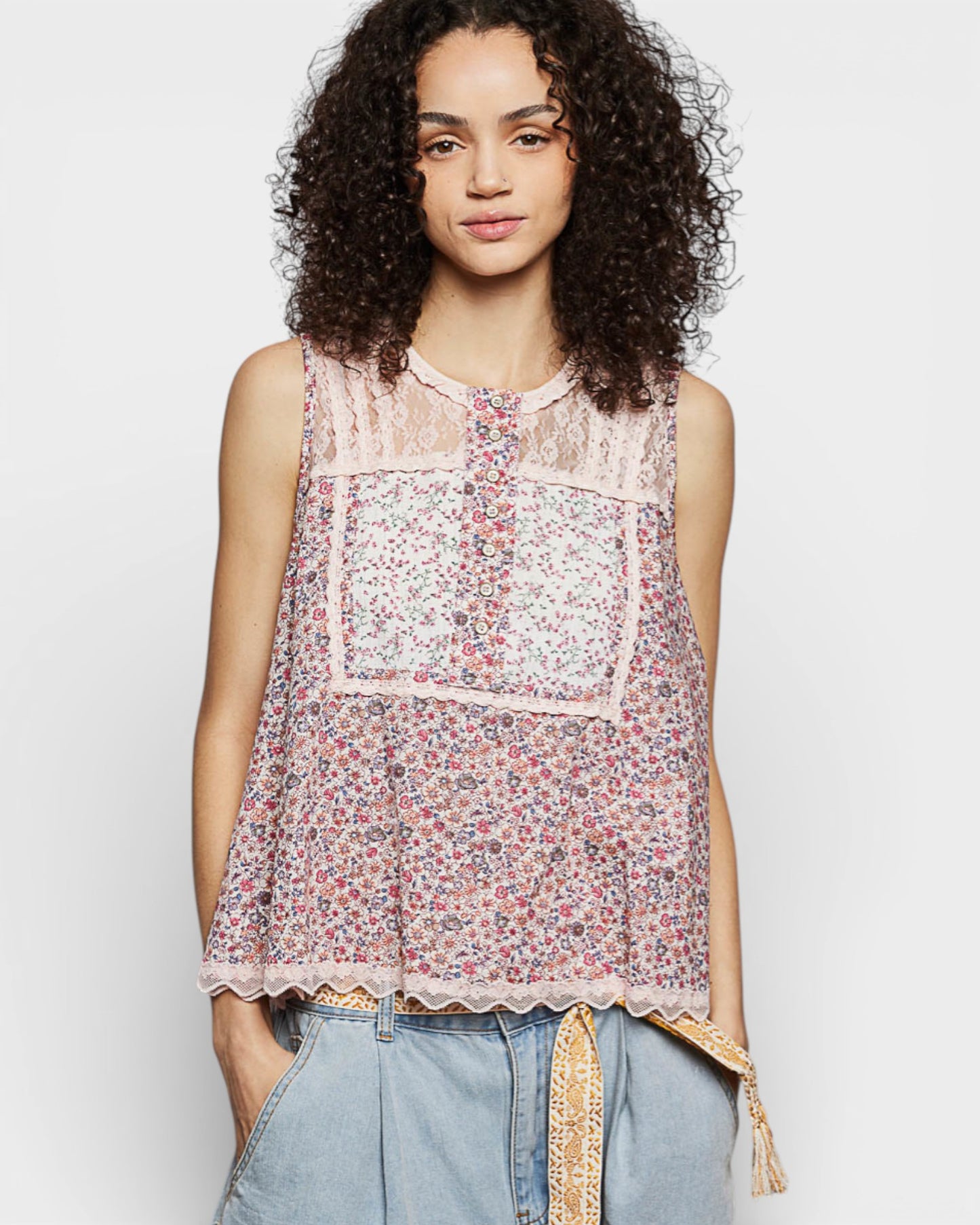 Woman wearing a floral sleeveless top with a plain background