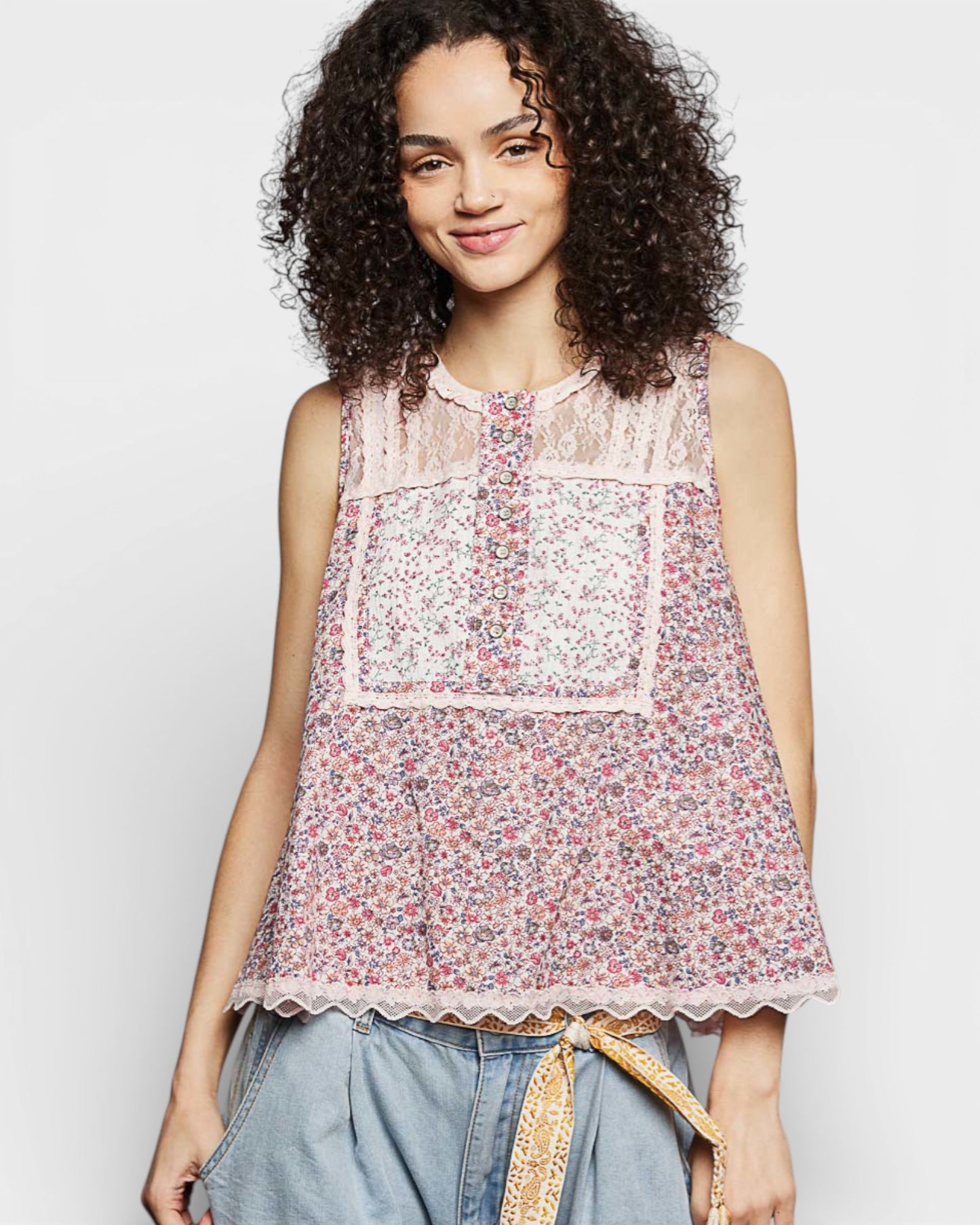 Woman wearing a floral sleeveless top with a plain background