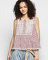 Woman wearing a floral sleeveless top with a plain background
