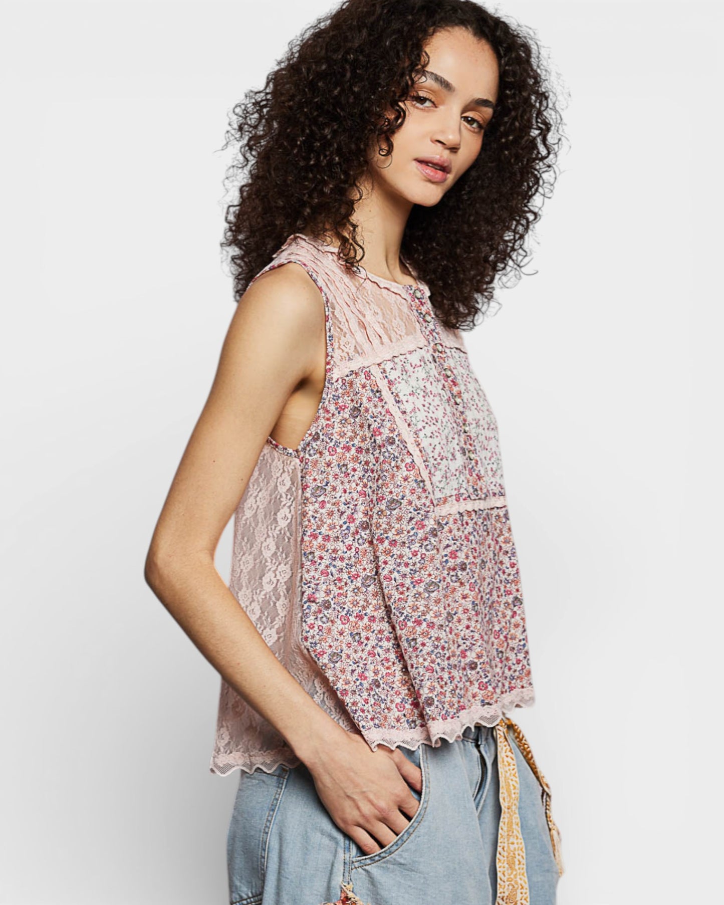 Woman wearing a floral sleeveless top with a plain background