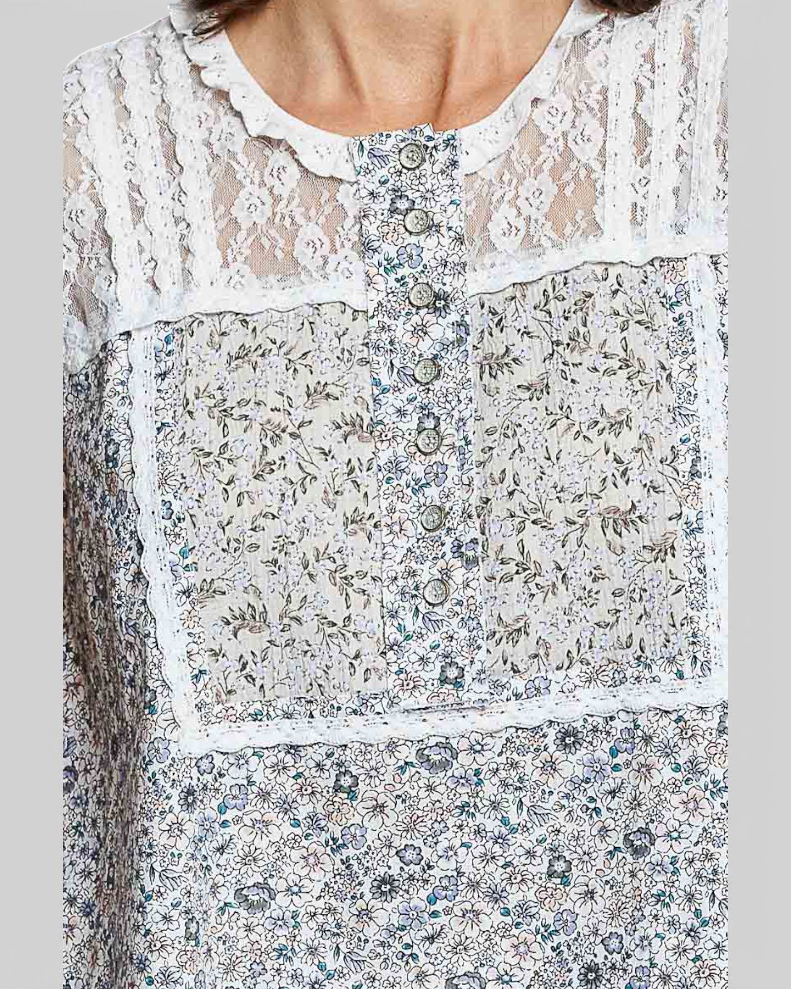 Close-up of a floral dress with lace details on a gray background