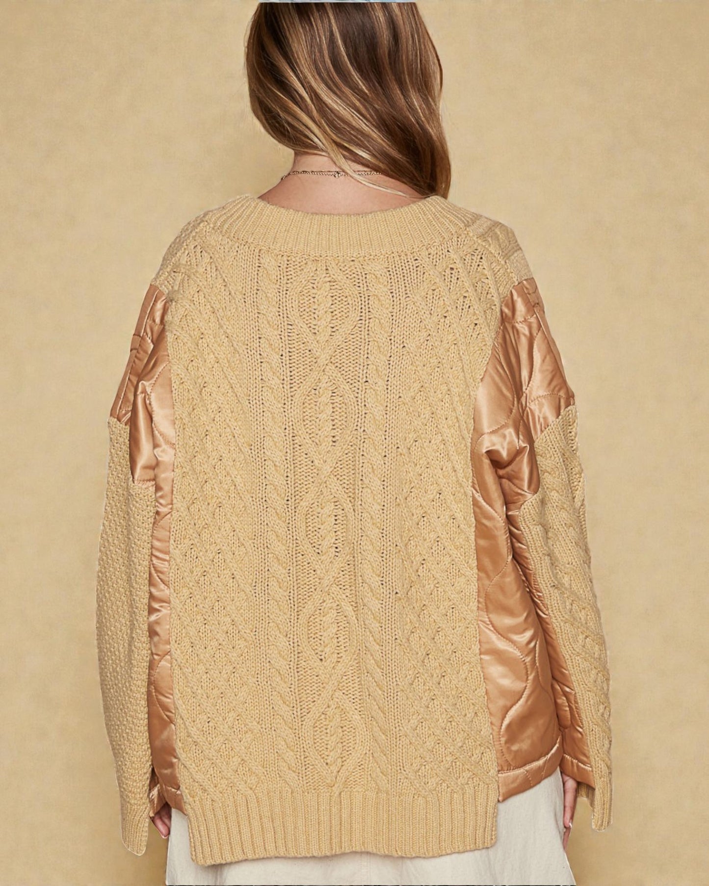Beige cable knit sweater with satin sleeves on a beige background