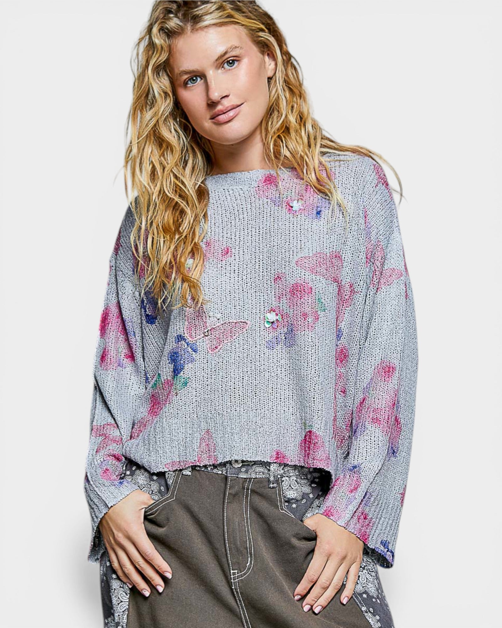 Woman wearing a floral-patterned sweater with a plain background