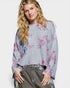 Woman wearing a floral-patterned sweater with a plain background