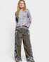 Person wearing a floral sweater and wide-leg jeans on a white background