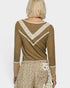 Person wearing a green long-sleeve top with lace details on a white background