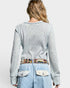 Person wearing a light gray textured sweater with colorful patterned front panel on a white background