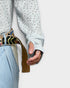 Person wearing a textured sweater and light blue jeans with a colorful belt on a white background