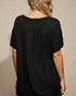 Black textured dress worn by a person on a beige background