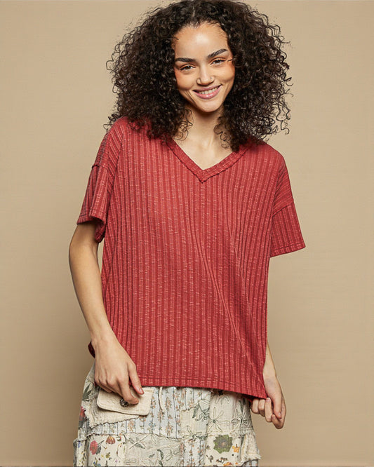 Woman wearing a red textured top against a beige background