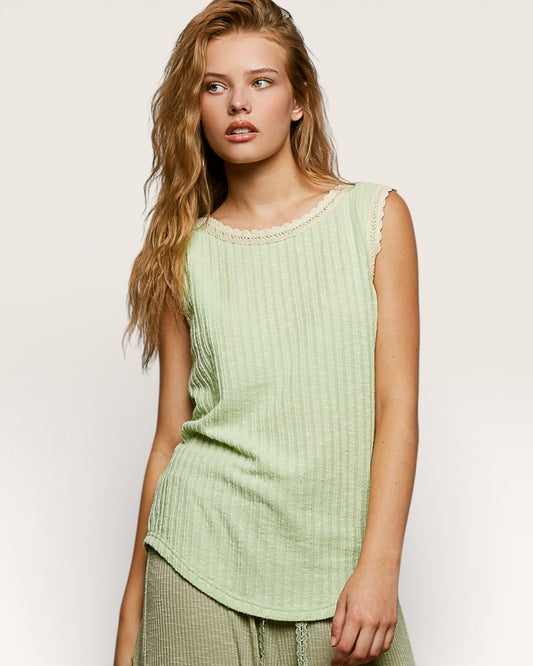 Woman wearing a light green sleeveless top against a plain background