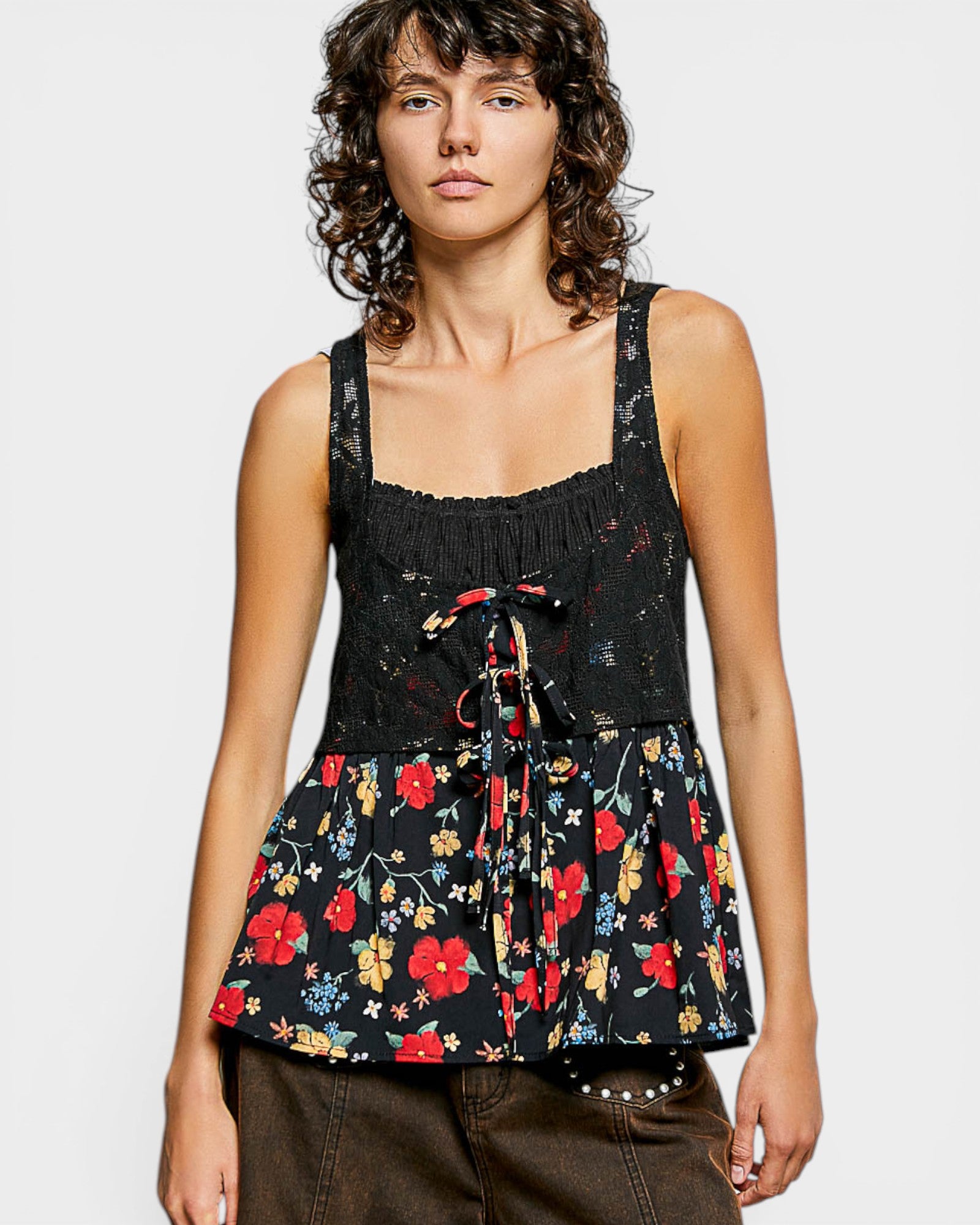 Woman wearing a black floral sleeveless top on a white background