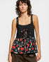 Woman wearing a black floral sleeveless top on a white background
