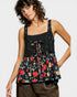 Woman wearing a black floral peplum top on a white background