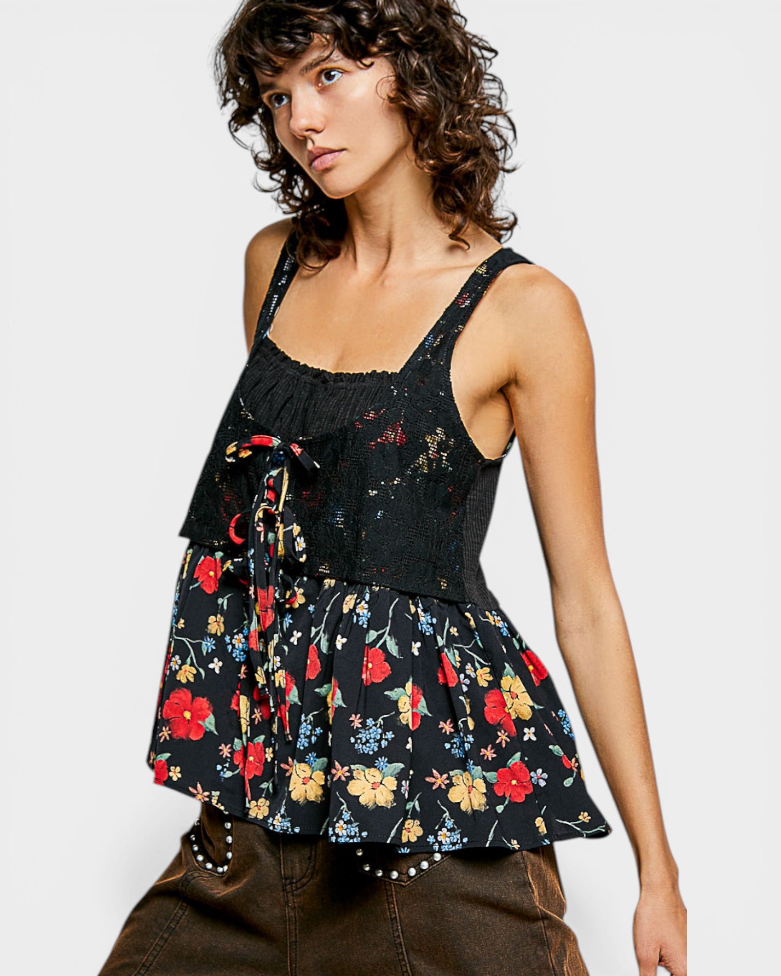 Woman wearing a black floral peplum top against a white background