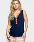 Woman wearing a navy sleeveless top with a colorful neckline against a white background